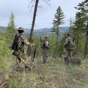 A group of hunters looks over a ravine