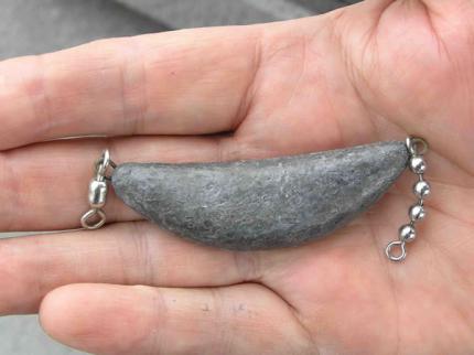A banana or trolling sinker in the palm of a fisherman's hand