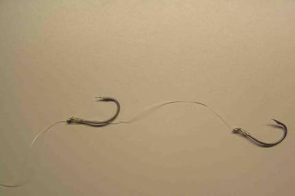 Photo of two hooks tide to fishing line with a couple inches of line connecting them together