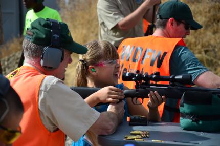Little girl receives shooting lesson from WDFW volunteer.